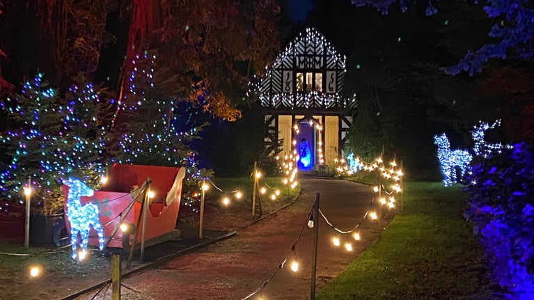 A view of Cheshire Cottage at Biddulph Grange Garden during Festive Lights. The path leading up to cottage is festooned by warm white lights.